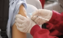 Pharmacist giving a free flu shot in the upper arm at Evergreen Compounding Pharmacy in southwest Calgary
